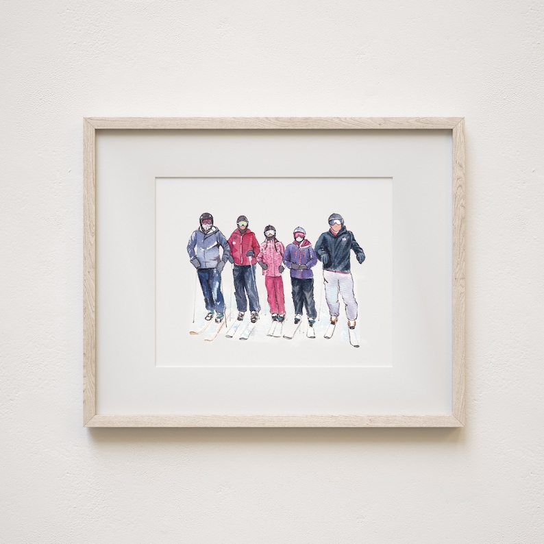 May include: A framed watercolor illustration depicting five individuals standing in a row, dressed in winter ski gear including helmets, goggles, jackets, and pants, with skis and poles visible, all presented within a light-colored wooden frame.