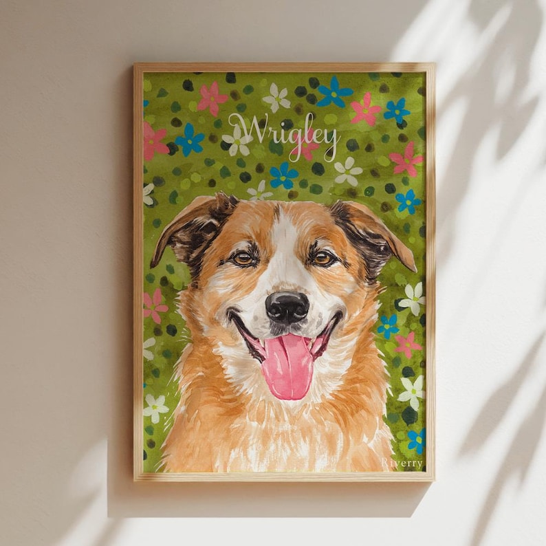 以下が含まれることがあります： 茶色と白の犬が舌を出している様子を描いた、額縁入りの長方形のウォールアートプリント。背景は緑色の野原で、小さなピンク、青、白の花が描かれています。白い筆記体でWrigleyという名前が記されています。