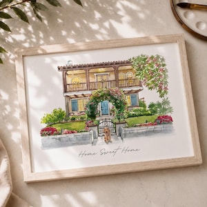 May include: Watercolor painting of a two-story house with a yellow facade, blue shutters, and a balcony. A dog sits near the gate. The words "Home Sweet Home" are written below the house. The artwork is framed in a light wood frame.