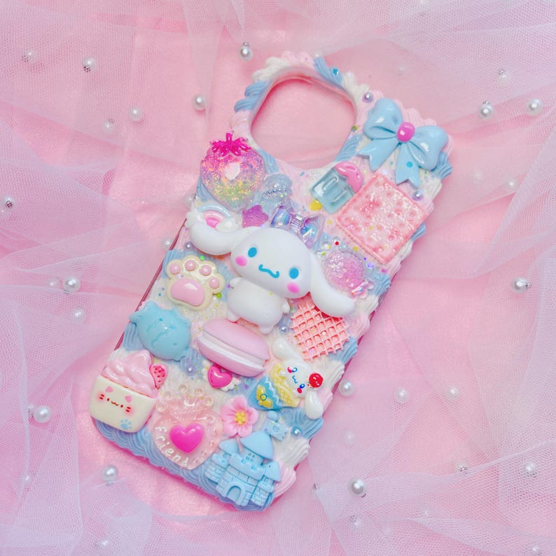 Pu&ograve; includere: Una custodia per telefono rosa, blu e bianca con un simpatico cane dei cartoni animati, un castello e altri elementi decorativi.
