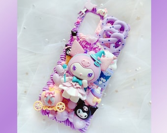 Puede incluir: Una funda de teléfono de color morado y rosa decorada con un personaje 3D, un carruaje y otros adornos. El personaje lleva un vestido rosa y un sombrero de bruja. La funda tiene un recorte para la cámara del teléfono.