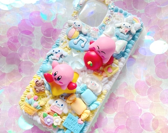 May include: A white phone case decorated with colorful 3D characters and designs. The case features a pink Kirby character, a pink and red character holding an apple, a blue and white character with a musical note, and a yellow star. The case also has a blue and white candy cane, a yellow candy, and a white cloud. The text "notes you can cherish" is written on a blue and white sign.