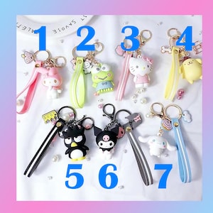 Pu&ograve; includere: Sette portachiavi colorati con diversi personaggi dei cartoni animati. I portachiavi sono numerati da 1 a 7. I personaggi includono una rana, un personaggio simile a Hello Kitty, un gatto bianco e nero, un coniglietto rosa e un cane bianco.