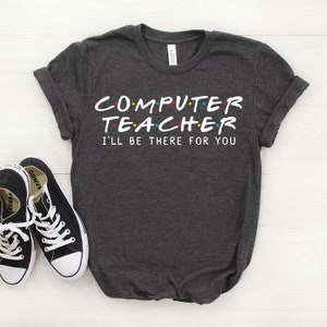May include: Dark gray t-shirt with the text "COMPUTER TEACHER I'LL BE THERE FOR YOU" in a white font with colorful dots. The text is styled to look like the "Friends" logo.