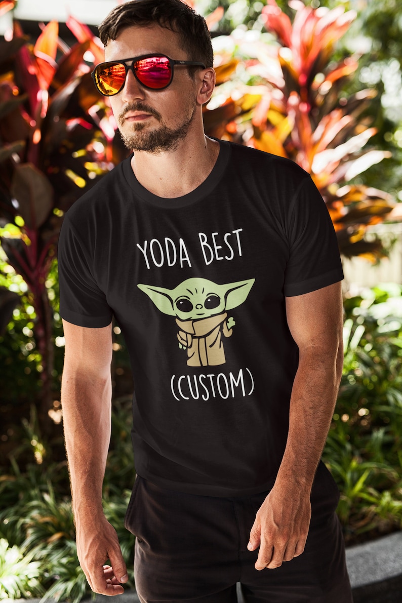 May include: Black t-shirt with a white graphic of a green baby Yoda character with the text "Yoda Best (Custom)"