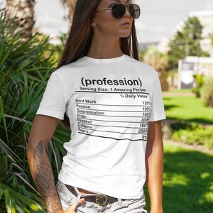 May include: White t-shirt with the text "(profession)" and a nutrition facts label listing "Hard Work," "Passion," and other qualities. The shirt is worn with denim shorts and sunglasses.
