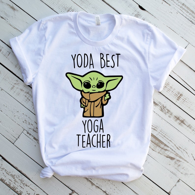 May include: White t-shirt with a green cartoon character and the text "Yoda Best Yoga Teacher".