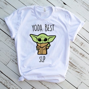 Puede incluir: Camiseta blanca con un personaje de dibujos animados verde y el texto "YODA BEST SLP".