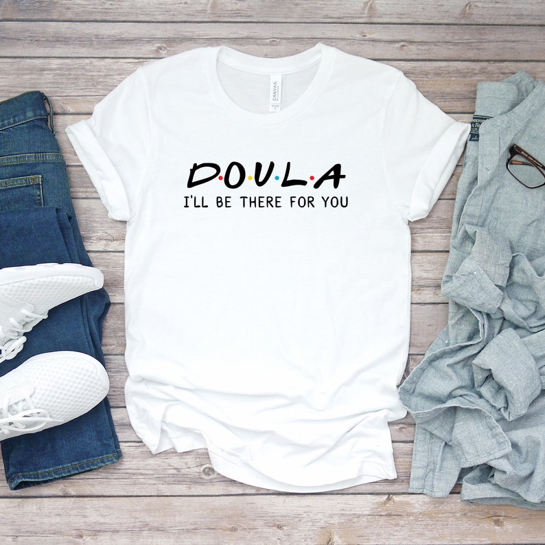 May include: White t-shirt with black text that reads "DOULA I'LL BE THERE FOR YOU" in a font similar to the "Friends" logo.