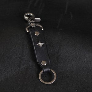 Clip en cuir clouté sur le porte-clés. Lanière. NOIR et nickel