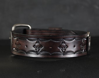 May include: A brown leather belt with a silver buckle and skull design.