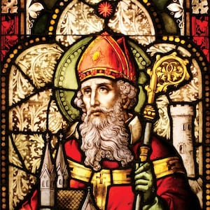 May include: A stained glass window depicting Saint Patrick, a Christian saint and patron saint of Ireland. He is shown wearing a red and gold mitre, a red robe, and holding a crosier. The window also features a small church building and the text "SAINT PATRICK Pray for us."