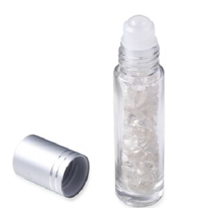 May include: A clear glass roller bottle with a silver cap and a white roller ball. The bottle is filled with small, clear crystals.