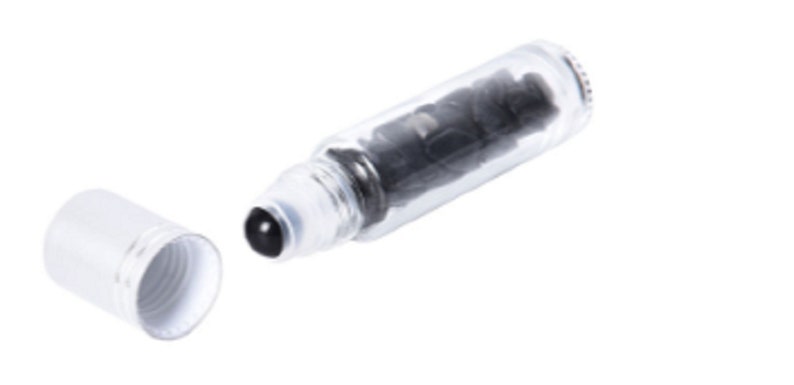 May include: A clear glass roller bottle with a black roller ball and a white cap. The bottle is filled with a dark liquid.