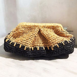 Peut inclure: Une pochette en paille tressée avec une bordure noire. Le sac a une forme arrondie et une surface texturée.