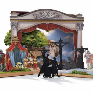 May include: A wooden diorama depicting a religious scene with painted figures and a backdrop of a sky and mountains. The diorama includes a king, soldiers, and figures on crosses, with a red curtain and architectural elements.