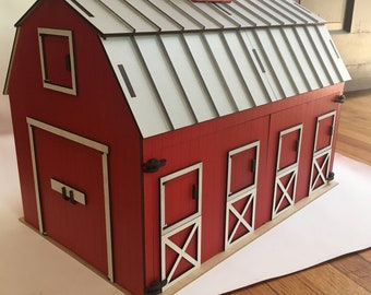 May include: A red barn model with a white roof and a rooster weathervane. The barn features multiple doors and windows with white trim and a wooden base. The design is a miniature replica of a classic barn.