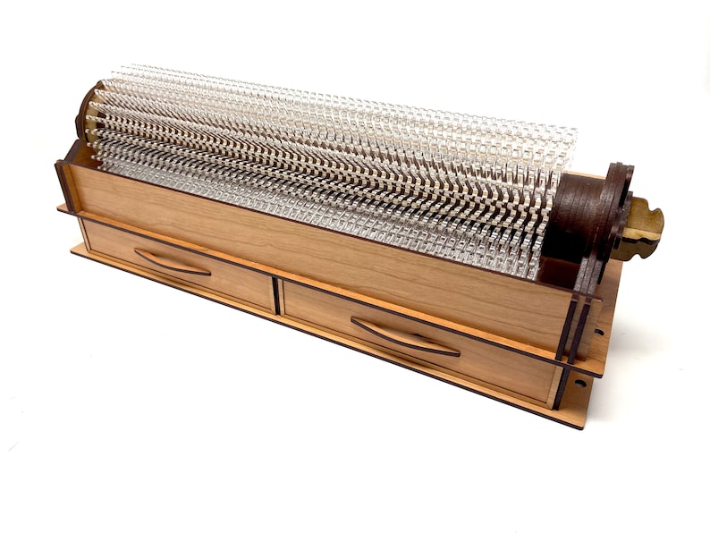 May include: A wooden storage box with two drawers and a clear plastic cylinder with a brown wooden base. The cylinder is filled with clear plastic pins.