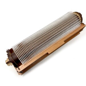 May include: A wooden frame with a clear plastic brush roller inside. The roller is made of many small, clear plastic bristles.