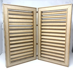 Può includere: Due persiane in legno con finitura marrone chiaro e lamelle orizzontali. Le persiane sono chiuse e incernierate insieme.