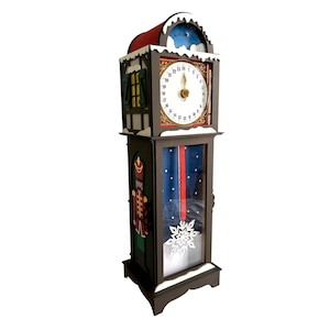 May include: A decorative wooden grandfather clock with a red roof and white snow accents. The clock face is white with black numbers and gold hands. A painted nutcracker soldier is on the side, and a snowflake is on the glass door.