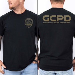 May include: Black t-shirt with a gold graphic of a Gotham City Police Department badge on the front and "GCPD GOTHAM CITY POLICE DEPARTMENT" on the back.