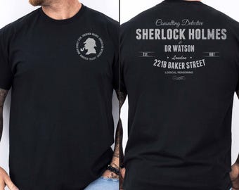 May include: Black t-shirt with a graphic print of Sherlock Holmes and Dr. Watson. The text reads "Consulting Detective Sherlock Holmes & Dr. Watson, Est. 1887, London, 221B Baker Street, Logical Reasoning".
