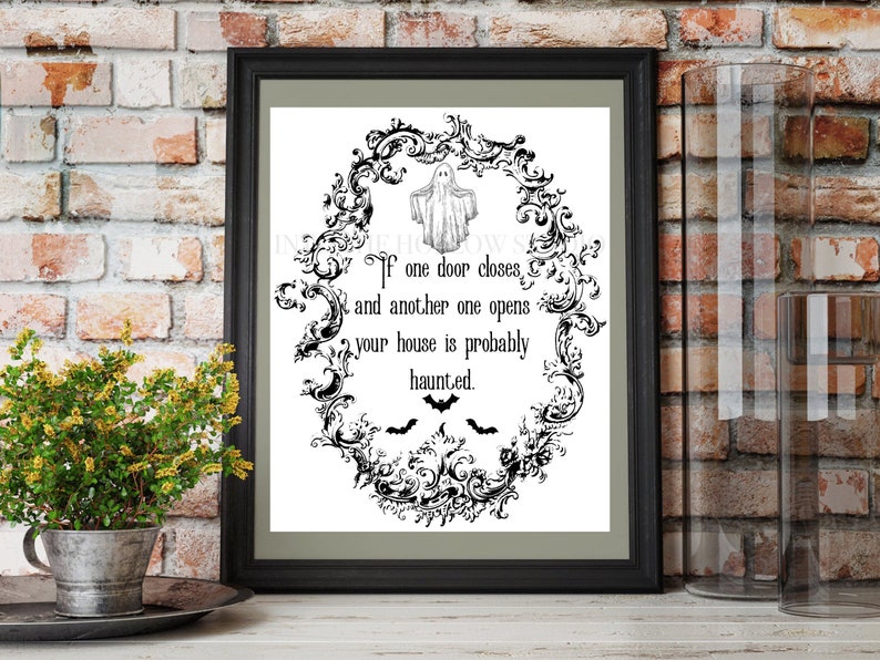 May include: Black and white printable Halloween sign with a spooky ghost and bats. The sign reads "If one door closes and another one opens your house is probably haunted."