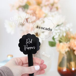 May include: Four clear acrylic food labels with black lettering. The labels read "Organic Ginger", "Avocado", "Red Peppers", and "Basil".