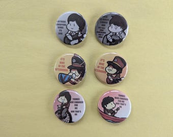 May include: Six round pinback buttons with cartoon illustrations and text. The buttons feature images of a person playing an instrument, and other illustrations with text that reads "Northern Downpour Sends Its Love", and "It's Nine in the Afternoon".
