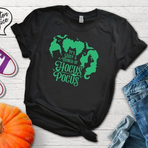 May include: Black t-shirt with a green graphic of the Sanderson sisters from the movie Hocus Pocus. The text reads "It's just a bunch of Hocus Pocus".