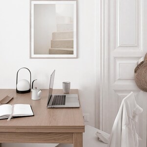Peut inclure: Un bureau blanc avec un ordinateur portable, une lampe blanche, une th&eacute;i&egrave;re blanche, une tasse blanche et un carnet. Le bureau est dans une pi&egrave;ce aux murs blancs et une porte blanche. Il y a une chaise blanche &agrave; l'arri&egrave;re-plan.