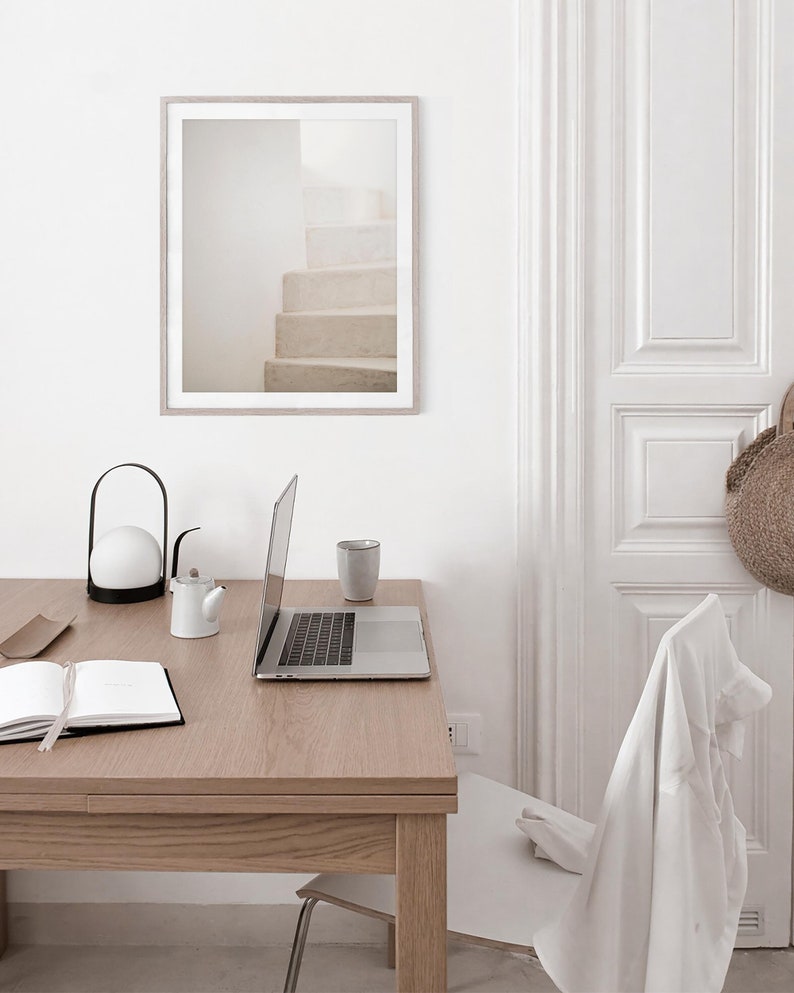 Peut inclure: Un bureau blanc avec un ordinateur portable, une lampe blanche, une th&eacute;i&egrave;re blanche, une tasse blanche et un carnet. Le bureau est dans une pi&egrave;ce aux murs blancs et une porte blanche. Il y a une chaise blanche &agrave; l'arri&egrave;re-plan.