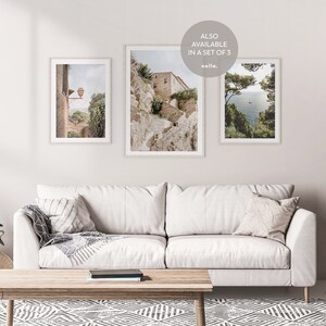 K&ouml;nnte beinhalten: Drei gerahmte Fotografien italienischer Landschaften. Das erste Foto zeigt ein Steinhaus mit einem Laternenpfahl im Vordergrund. Das zweite Foto zeigt einen Steinweg, der einen H&uuml;gel hinauf zu einem Geb&auml;ude f&uuml;hrt. Das dritte Foto zeigt einen Blick auf das Meer von einer Klippe mit B&auml;umen im Vordergrund. Der Text "ALSO AVAILABLE IN A SET OF 3" ist in der oberen rechten Ecke des Bildes sichtbar.