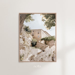 May include: A stone building with a stairway leading up to it. The building is surrounded by trees and rocks. The image is taken from a low angle, looking up at the building.