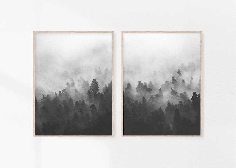 May include: Two black and white framed prints of a foggy forest scene. The prints are hung on a white wall.