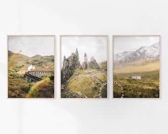 May include: Three landscape photographs in wooden frames. The first shows a train traveling over a stone bridge in a mountainous region. The second shows a rocky mountain range with fog in the background. The third shows a small white house in a field with a mountain range in the background.
