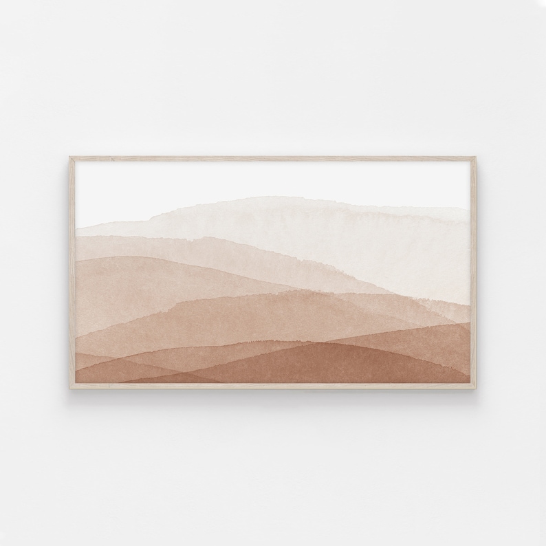 May include: Abstract watercolor painting of a landscape with brown and white hues. The painting is framed in a light wood frame.