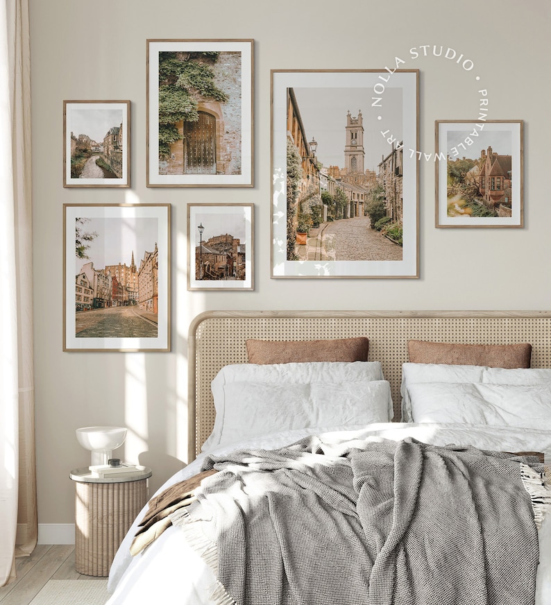 May include: A collection of five framed prints featuring vintage photographs of a European city. The prints are arranged in a grid pattern on a light beige wall above a wicker headboard bed.