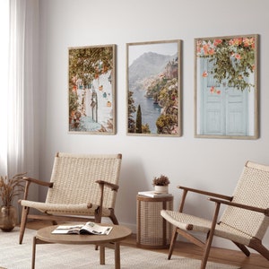 May include: Three framed photographs of coastal scenes. The first shows a white building with a blue door and a green vine. The second shows a view of a rocky coastline with a blue sea. The third shows a white door with a pink flower vine.