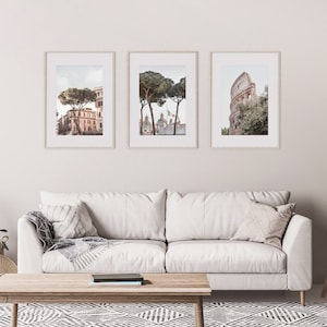 May include: Three framed prints of Rome, Italy. The first print shows a street scene with a building and a tree. The second print shows a tree in front of a building with a flag. The third print shows the Colosseum.