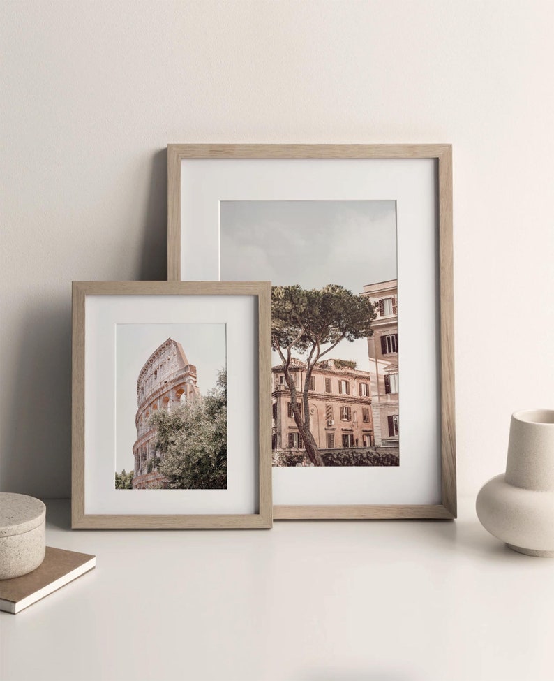 May include: Two framed photographs of Rome, Italy. The larger photo shows a tree in front of a building with a cloudy sky. The smaller photo shows a portion of the Colosseum.