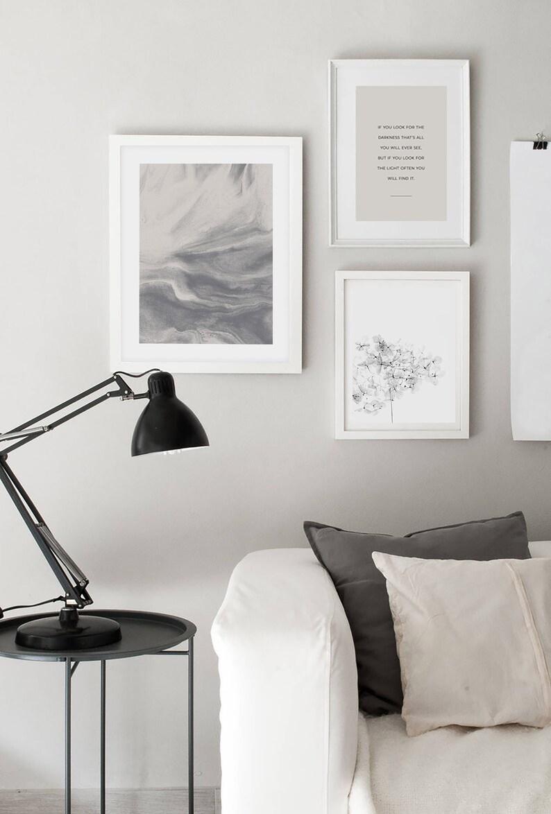 May include: Three framed prints on a white wall. The left print is a gray abstract design. The middle print has a quote that reads "If you look for the darkness that's all you will ever see. But if you look for the light often you will find it." The right print is a black and white image of a flower.