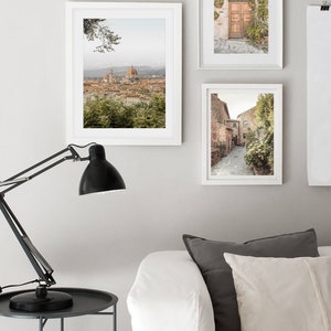 K&ouml;nnte beinhalten: Drei gerahmte Fotografien italienischer Architektur. Das obere Foto zeigt einen Blick auf die Stadt Florenz mit dem Dom im Hintergrund. Das mittlere Foto zeigt eine Holzt&uuml;r mit einem Ziegelbogen. Das untere Foto zeigt eine schmale Kopfsteinpflasterstra&szlig;e mit Geb&auml;uden auf beiden Seiten.