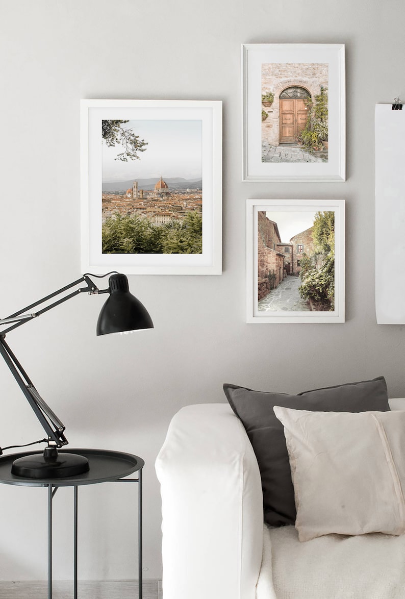 K&ouml;nnte beinhalten: Drei gerahmte Fotografien italienischer Architektur. Das obere Foto zeigt einen Blick auf die Stadt Florenz mit dem Dom im Hintergrund. Das mittlere Foto zeigt eine Holzt&uuml;r mit einem Ziegelbogen. Das untere Foto zeigt eine schmale Kopfsteinpflasterstra&szlig;e mit Geb&auml;uden auf beiden Seiten.