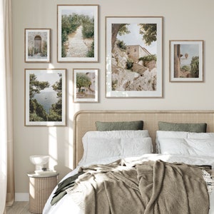 Pode incluir: Um quarto com uma cama com um edredom branco e uma manta de l&atilde; marrom. A cabeceira &eacute; feita de vime tecido. H&aacute; cinco quadros emoldurados na parede acima da cama, todos representando cenas de uma pequena cidade na It&aacute;lia. Os quadros s&atilde;o de tamanhos diferentes e est&atilde;o dispostos em um padr&atilde;o sim&eacute;trico.