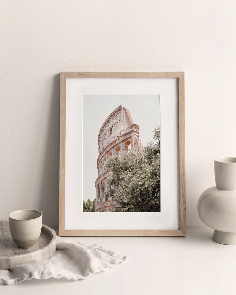 May include: A framed photograph of the Colosseum in Rome, Italy. The photo is taken from a low angle, showing the top of the structure and some trees in the foreground.