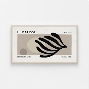 May include: A framed print of a black and white abstract art piece by Henri Matisse. The print features a stylized black branch with rounded leaves against a beige background. The text "H. Matisse", "N°14", "Berggruen & Cie", and "France, 1952" is included in the print.