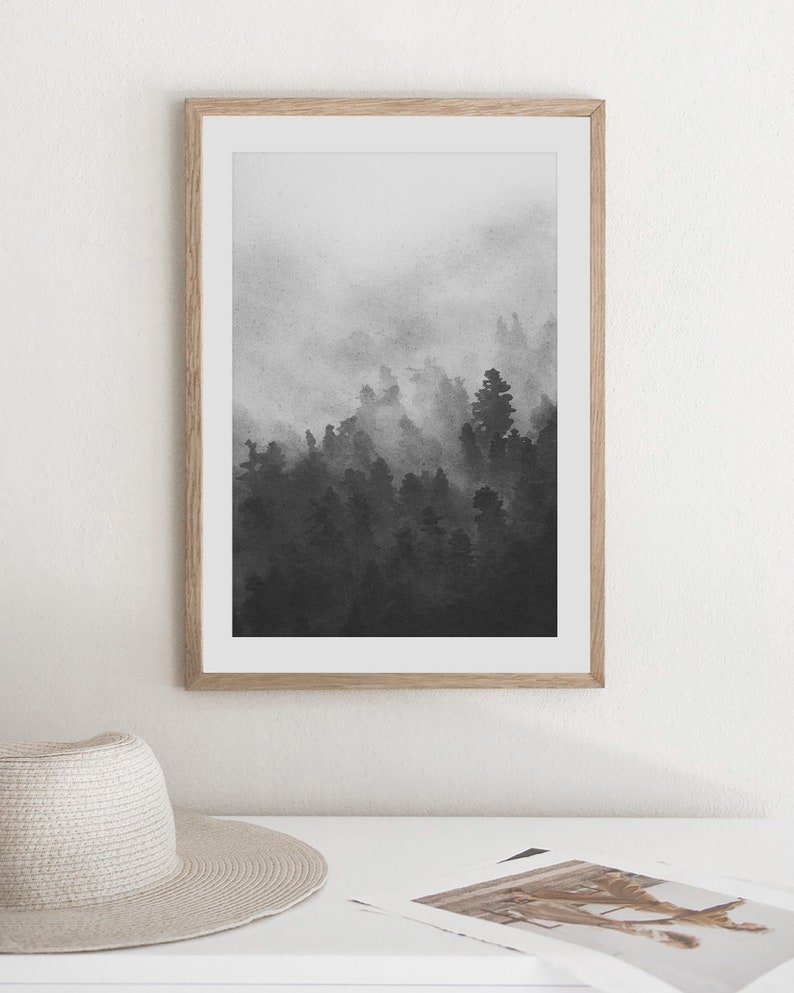 May include: A black and white framed print of a foggy forest scene. The trees are silhouetted against the white fog.