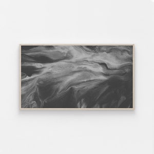May include: Abstract black and white painting with swirling, marbled patterns. The painting is framed in a light wood frame.
